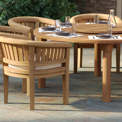 Close up view of 180cm round teak garden table surrounded by 8 San Francisco chairs with cream cushions.