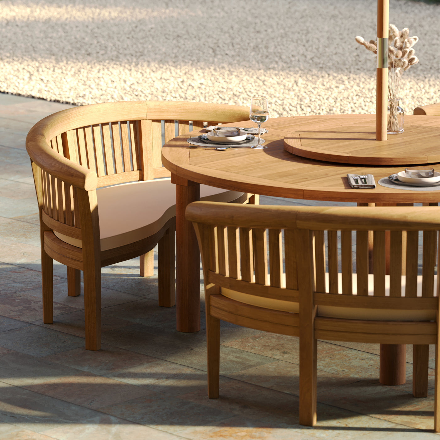 Spacious round teak dining table with elegant curved-back chairs