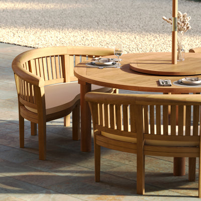 Spacious round teak dining table with elegant curved-back chairs