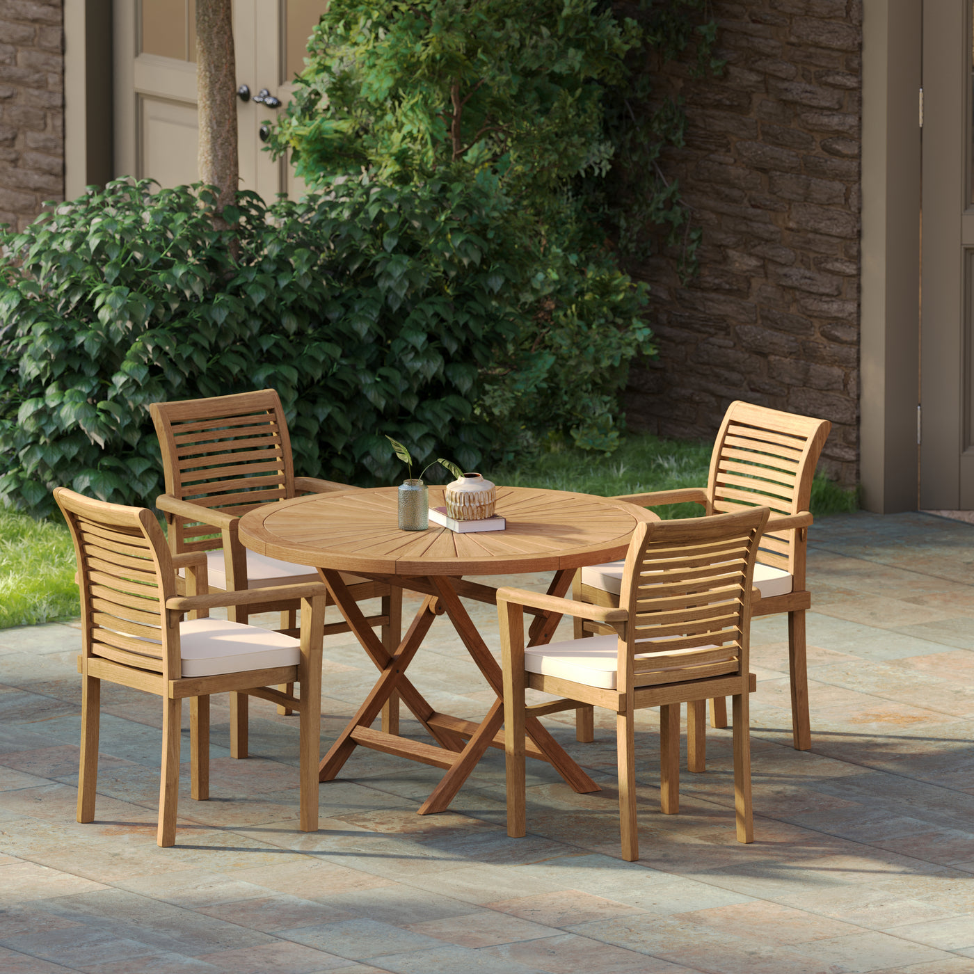 Teak garden outdoor set featuring a 120cm round Sunshine folding table with four Oxford stacking chairs and cream cushions on a stone patio.