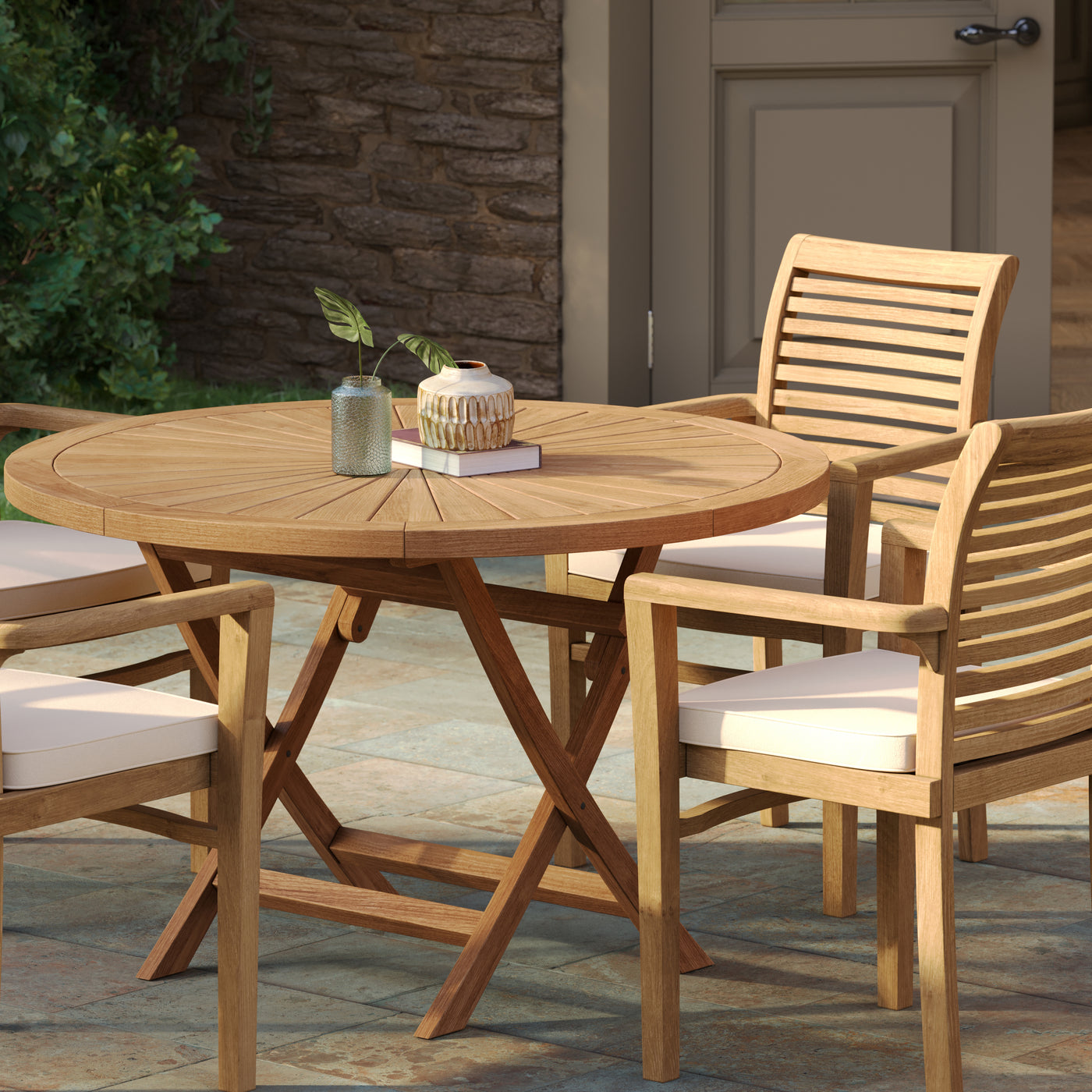 Top view of teak garden furniture set with 120cm round Sunshine table and four Oxford stacking chairs arranged outdoors.