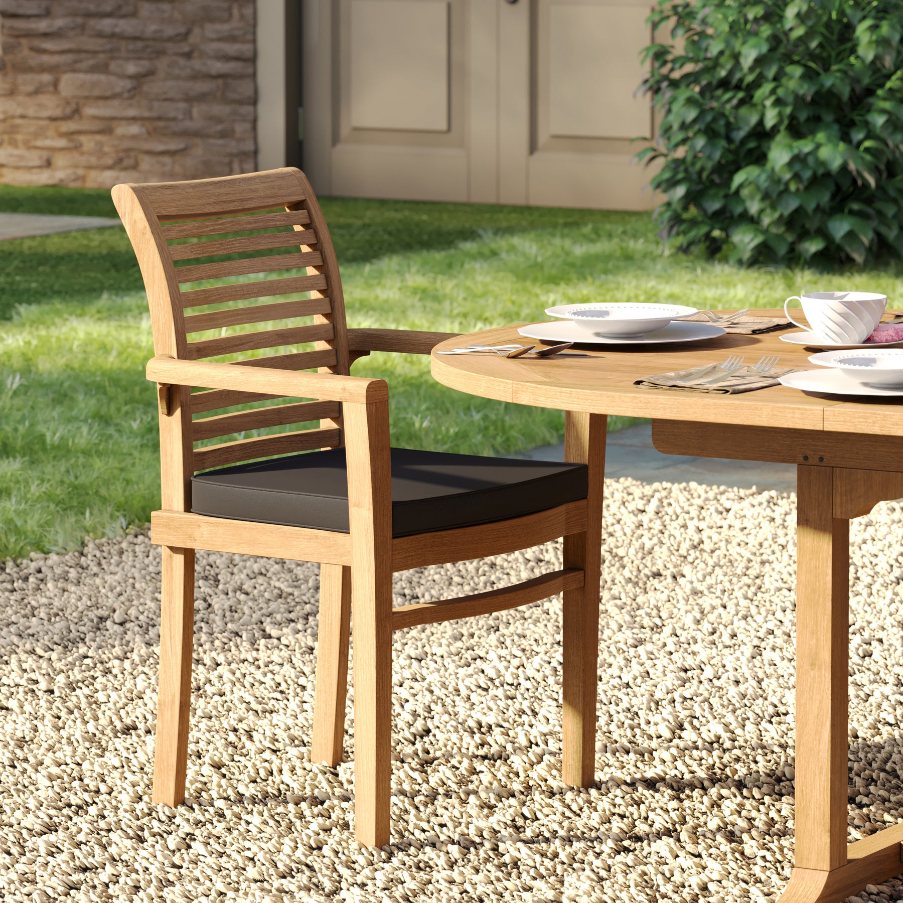 Teak garden outdoor set with 180–240cm oval table and 6 Oxford stacking chairs placed in front of a stone façade home.